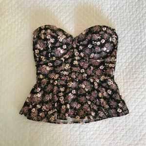 Blommig peplumtopp från Bikbok i storlek XS - Så fin blommig peplumtopp med dragkedja bak, helt oanvänd!