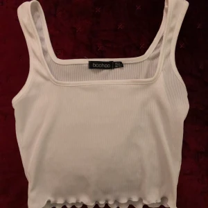 vit crop top - detta är en jättefin crop top från Boohoo som tyvärr inte passar mig längre!! den är i bra skick men är lite lite sliten (kolla bild 2) men det syns knappt när den sitter på!! frakt ingår ej i priset!!