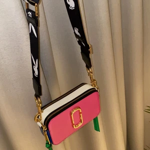 Marc Jacobs väska med playboyband - Äkta väska från Marc Jacobs, bandet är också från Marc Jacobs! Oanvänd! Bandet är reglerbart! Kostar nypris runt 3500kr-4000. Skriv till mig för mer ingående bilder! 🤎