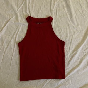 Vinrött ribbat linne med krage - Vinrött ribbat linne med en krage som sitter som en turtleneck. Linnet är knappt använt och är köpt på Carlings av märket /STAY. Storleken är S. 
