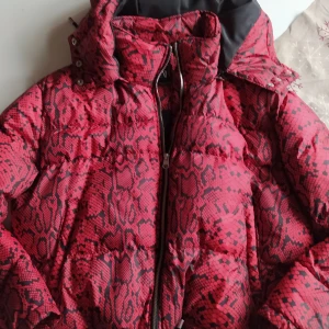 Nyskick Zara kort vinterjacka röd snakeprint  - Så läcker jacka,kort modell, blixtlås,muddar. Otroligt skön och varm! Sista bilden är inte min  men visar hur sjukt snygg den är på. 