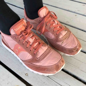  - Korallfärgade sneakers i använt men fräscht skick.  Några små skavanker syns på bilderna, vänster skosula bak lös, dekorativ söm fram har börjat gå upp och en centimeterlång liten reva tyget. 