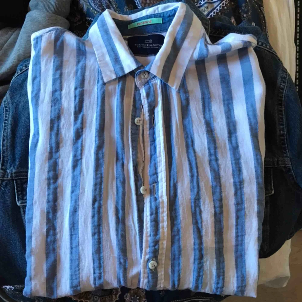 Blå och vitrandig linneskjorta från scotch & soda. Mycket bra skick för att vara använd.  Köpare står för frakt på 59kr :). Skjortor.