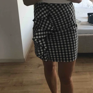  - Kort rutig kjol med volang fram till. Storlek 38. Pris inkluderar frakt. 