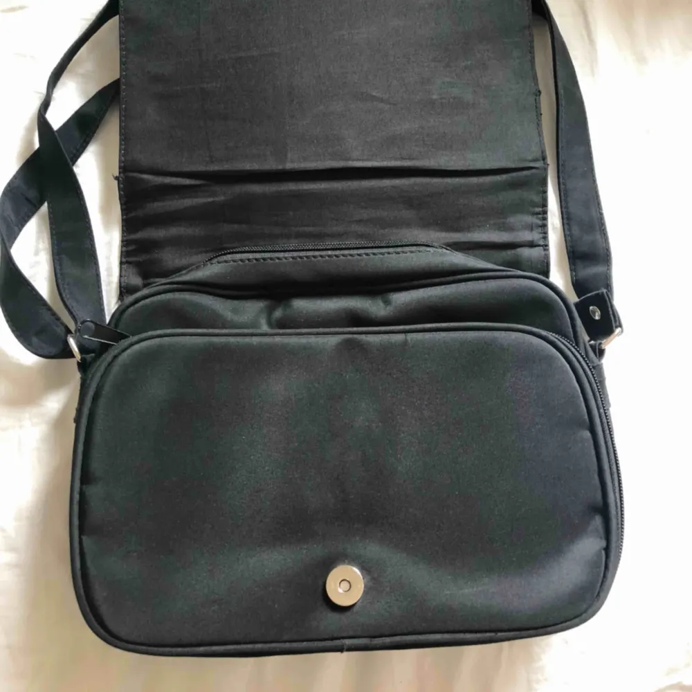 Jättecool svart handväska köpt second hand! Den har tre ytterfack på väskan och väskan i sig har två (se bild 3) Köpt på emmaus💜Köpare står för frakt! . Väskor.