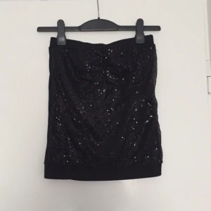  - Glittrig ärmlös topp i svart. 