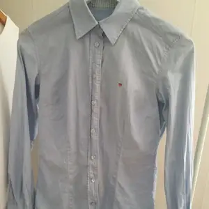 Ljusblå skjorta från Gant. Nästan helt oanvänd, i väldigt fint skick. Säljes då den inte kommer till användning.