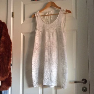  - Riktigt snygg vit spetsklänning med djup rygg och knytning i ryggen. Aldrig använd.