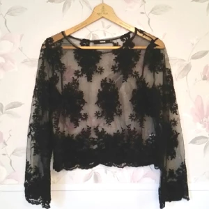  - svart  broderad från bikbok. Inte magtröja men slutar precis under naveln/där jeansen börjar. Färgen: Genomskinlig svart. Storlek M.