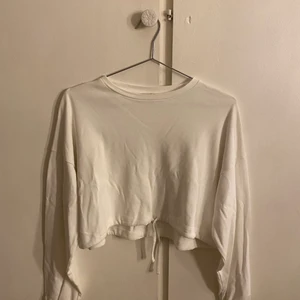 Vit croppad sweatshirt strl XS - Säljer en vit croppad sweatshirt från h&m. Den har snörning på slutet av armarna och snörning i slutet av tröjan och den är i storlek XS. Fick den i present för nåt år sedan men det är inte min stil så den har inte kommit till någon användning (aldrig använd) 