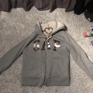 Gap Hoddie - En zip-up hoddie från gap i stlk M, den e fluffig på Insidan väldigt skön o mysig. Säljer pga inte riktigt min stilval har inte använt sen jag fick den 