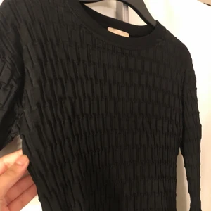 Svart ribbad klänning från hm trend - En svart ribbad klänning från h&m, använd endast en gång. Kommer till mitten av låret. Den sitter tajt på.