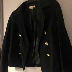 Svart kavaj med guldknappar  - En svart kavaj med guldknappar, jätte snygg!!! Köpt från H&M. Har dock aldrig kommit till användning. Sitter inte heller obekvämt som andra kavajer.