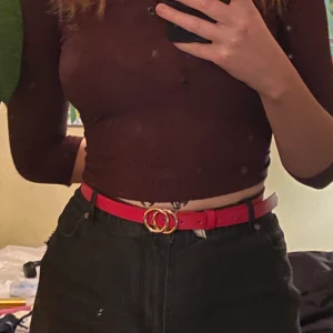 Rött skärp med gulddetaljer - Rött skärp med guldspänne från Gina Tricot. Storlek M-L. I princip oanvänt. Frakt 26 kr eller hämtas i Sollentuna Centrum.