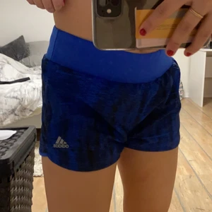 Adidas träningsshorts, S - Blåa Adidas träningsshorts med inbyggd trosa (vet inte riktigt vad det heter, bild 3), fråga gärna om mer bilder vid intresse. Väldigt skönt material, nästan aldrig använda och i super bra skick! Frakt tillkommer💙💙