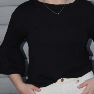 Svart Långärmad Tröja Med Utsvängda Armar - Säljer denna super fina svarta topp med utsvängda armar och snygg passform! Den är i strl. XS. Priset är 75kr+frakt 💕💕 (OBS. Fotade medans det snöade och därför är de små vita prickar av snö på tröjan, köpare står för frakt). 