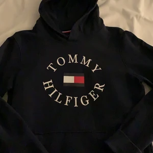 Marinblå Tommy Hilfiger hoodie - Marinblå Tommy Hilfiger hoodie med luva och ficka, endast använd några gånger, nyskick, storlek 176 i barnstorlek men är ganska stor så passar M på vuxenavdelningen, 250kr