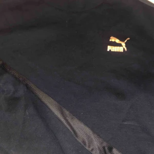  - Svart magtröja från puma. Logga i roséguld och utsvängda armar med annat material längst ut. Sitter väldigt snyggt.