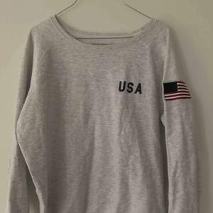 Mysig ljusgrå tröja som det står i USA på. 
