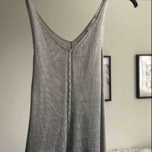  - Silvrig ”stickad” vintage klänning från asos, köpt i London under tidigt 90-tal. Faller på kroppen efter ens kurvor! I fint skick förutom ett litet uttänjt hål. Finns silvrig body att köpa till att ha under! ✨