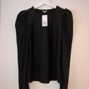 Svart glittrig långärmad top - Svart långärmad glittrig top i stl s aldrig använd, etikett kvar. 