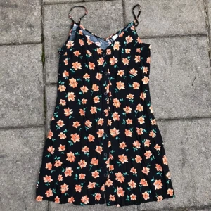 Blommig miniklänning - Säljer denna söta blommiga klänningen med knappar. Köptes förra sommaren men har aldrig använt den! ❤