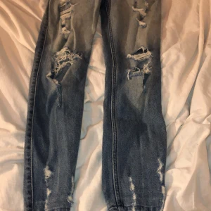 Hollister jeans med hål - Ripped jeans från hollister. Trådarna är väldigt slitna då därför är det lågt pris, annars är de bra kvalite. De är typ som skinny jeans med grovare tyg. 