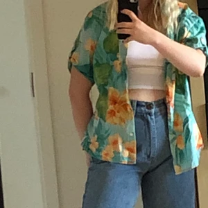 Hawaii skjorta - Säljer denna blommiga skjorta med Hawaii vibes. Nästan helt oanvänd och i jättebra skick. Storlek L, men sitter fint på mig som vanligtvis är S. Har liknande annonser på min profil :)