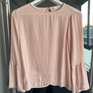 Blus från Mango - Ljusrosa blus från mango i tunt material med ärmar med flairmodell och fransdetaljer. Använd fåtal gånger. Köparen står för frakt🌸