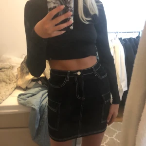 Svart minikjol med vita sömmar strl 34 - Tight svart minikjol från missguided, knappt använd. Sitter jättefint på kroppen, frakt tillkommer