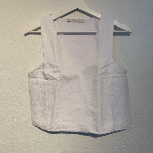 Vit top från Zara - Fin vit top med mönster. Något styv i materialet