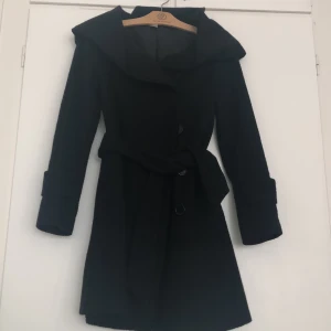 Kappa - Säljer nu en av mina två favorit kappor då den inte får plats i garderoben längre. Helt vanlig svart snygg kappa som alltid behövs.