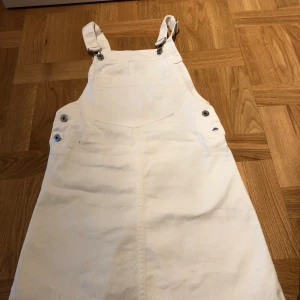 Vit jeanskjol  - Vit hängsle-kjol från HM.  Aldrig använd. Jättefin. 