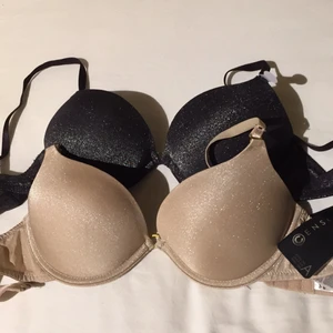  - 2st behå från märket CENSORED i storlek 75A. Den svarta är oanvänd och den beiga använd endast 1 gång. Super push-up (dock väldigt bekväma), glittriga samt avtagbara axelband. 40kr styck. Möts upp i Stockholm vid affär/ skickas med post. Avsändare står då för porto. 