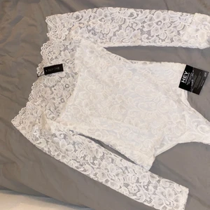 Body - Köpte denna body från Nelly för 300 kr, kom tyvärr aldrig till användning. Superfin enkel body i vit spets, string. Skulle säga att den fungerar som S/M. Kontakta mig vid intresse! Frakt tillkommer!