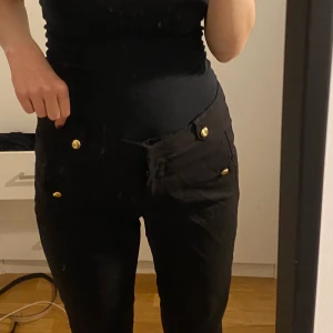 Svarta kostymbyxor - Byxor med guld detaljer. De har ett hål där bak men jag har sytt de och så har de ett hål i fickan. Ganska tighta. 