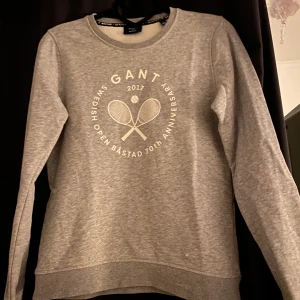 Sweatshirt från gant i storlek XS - En grå sweatshirt från gant i storlek XS. Den har ett hål på framsidan som man ser på ena bilden, därför det låga priset. Det går dock att sy ihop det så att det inte syns, men jag har inte brytt mig om det för att jag bara använt den hemma. 