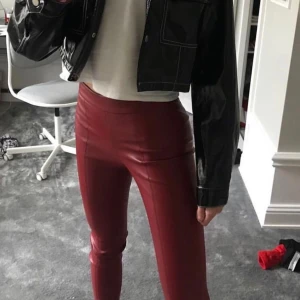 Zara röda skinn byxor - Så galet snygga skinnbyxor som passar till hoodie / snygg fest topp! Säljes pga platsbrist i garderoben! Har dragkedja på sidan ( se bild 2. ) Nypris, 399:-  