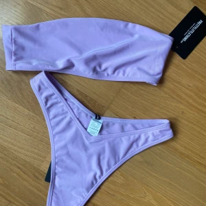 Lila Bikini  - Snygg bikini från pretty little things i ljuslila färg, helt oanvänd! Perfekt till sommarn, överdel är i storlek 36 och underdelen är i 34! Startpris 170, buda om ni vill ha den!!