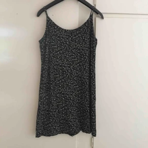  - Mörkblå småblommig (vita blommor) klänning i 90-talsmodell i skönt bomullstyg. Väldigt bekväm o mjuk i tyget. Från beyond retro. 