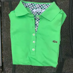 En grön lacoste skjorta som aldrig är använd och därför nyskick. Köpt utomlands så troligen fake