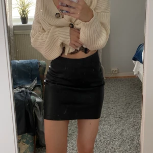 Skinnkjol  - Svart skinnkjol med dragkedja på sidan, använd endast en gång 