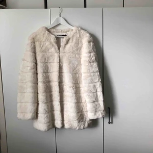  - Vit fuskpäls från Zara. Väldigt mjuk och har ett silkesfoder på insidan. Har fickor och knappar, se bilder ovan.