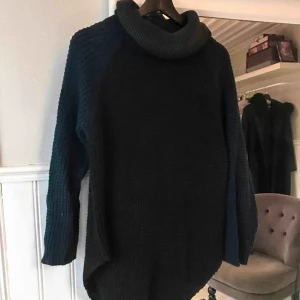  - Stor stickad polo, liknar hopes i modellen. Svart med marinblå armar. 