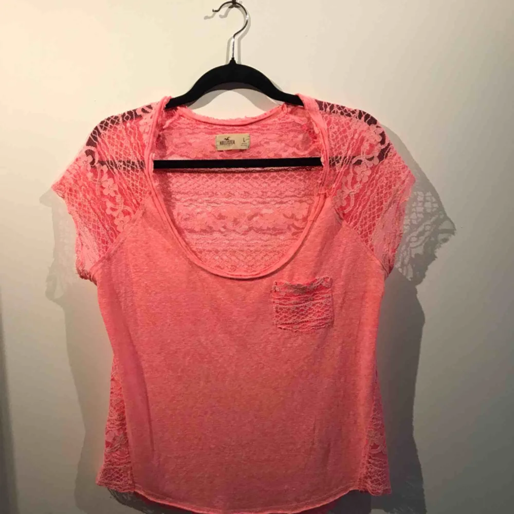 Säljer en rosa t-shirt med spets i ryggen från Hollister, i storlek L. Priset är med frakt inräknat. T-shirts.