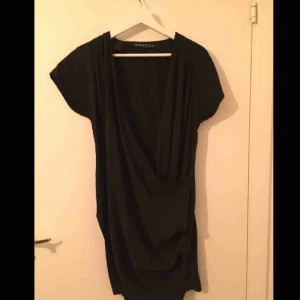  - Draperad marinblå/svart klänning från Norrback. 100% tencel/lyocell (tillverkas av cellulosamassa från träd från hållbarhetscertifierade plantage). Nyskick.