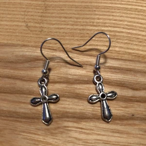 Kors örhängen hemmagjorda  - Hemmagjorda kors örhängen. Hängarna är nickelfria. Silverfärgade. Samfraktar Järna!