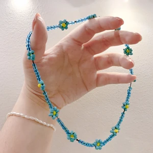 Pärlat halsband med blommor - Pärlat halsband med glaspärlor. Sitter fint runt halsen, lösare än en choker. Gjord med elastisk tråd för att passa alla. Frakt inkluderat i priset.