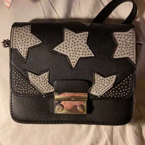 väska - en fin liten väska från zara med stjärnor på, har ett långt band men kan vikas in så det blir kort :)
