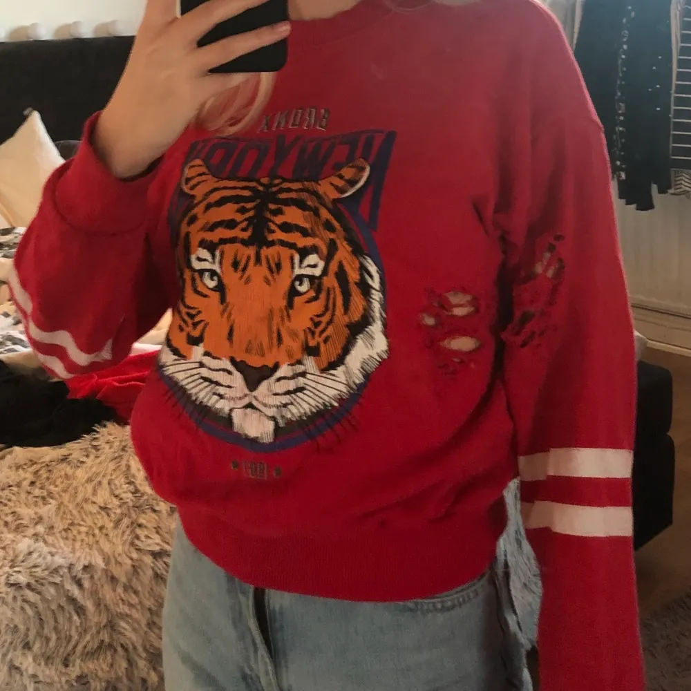 En fin röd sweatshirt ifrån ginatricot med tigertryck och slitningar. I mycket fint skick bortsett från de vita ränderna på armarna som är något slitna. 40kr + frakt.. Tröjor & Koftor.